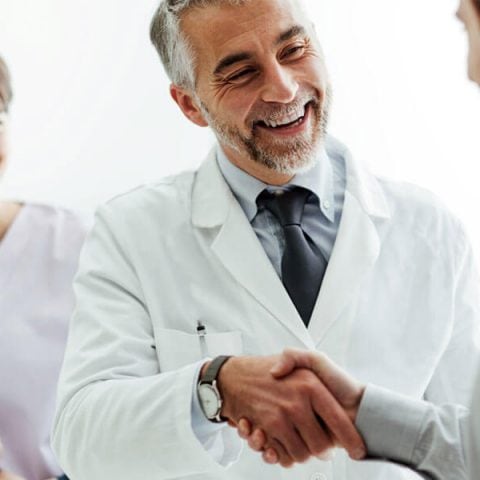 Dentist shaking hand with the Dental assistant after interview