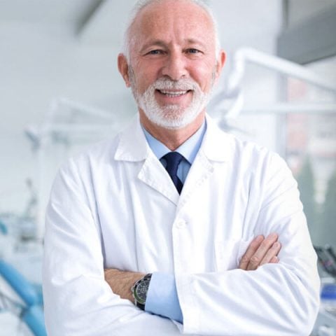 Dentist and his dental assiatant smiling for camera