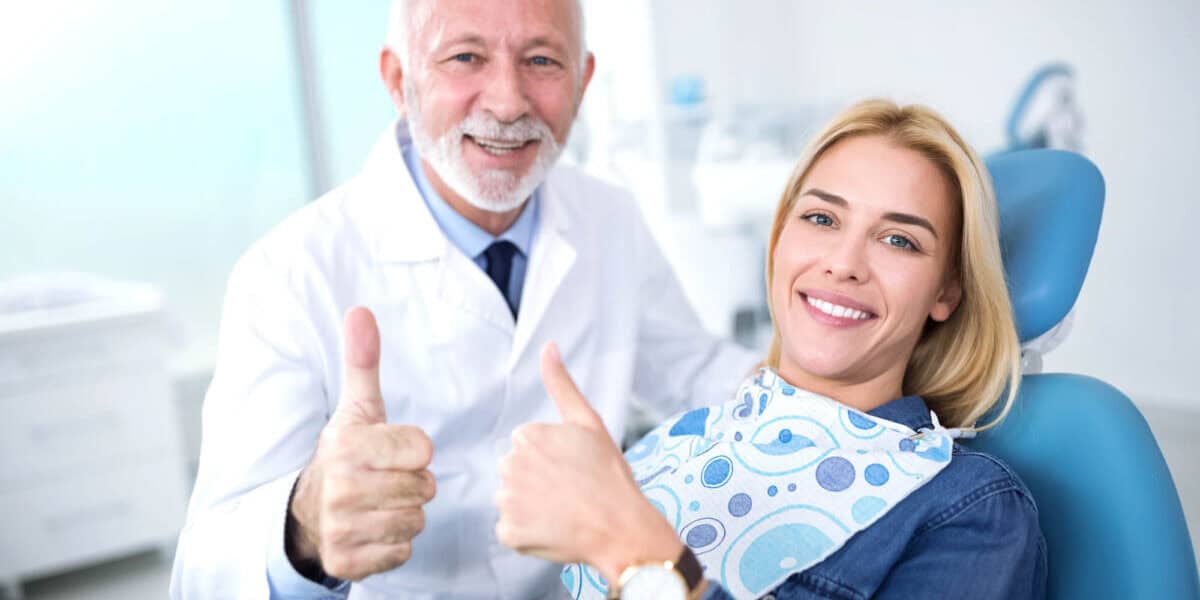 dentist and patient giving thumbs up after affordable gum care treatments