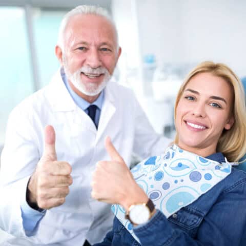dentist and patient giving thumbs up after affordable gum care treatments