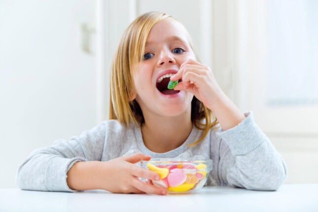 girl eating too much sweets a good candidate for kids dental cleaning near me