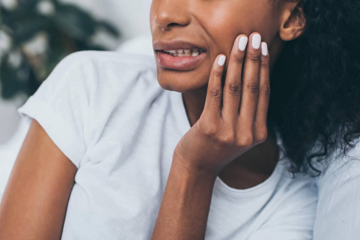 woman feeling pain from dental bridges for missing teeth