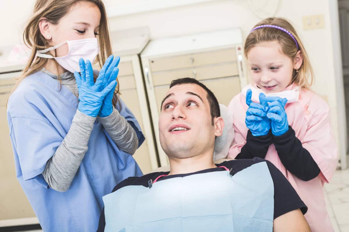 two-girls-playing-kids-dental-cleaning-near-me-pretend-with-their-dad