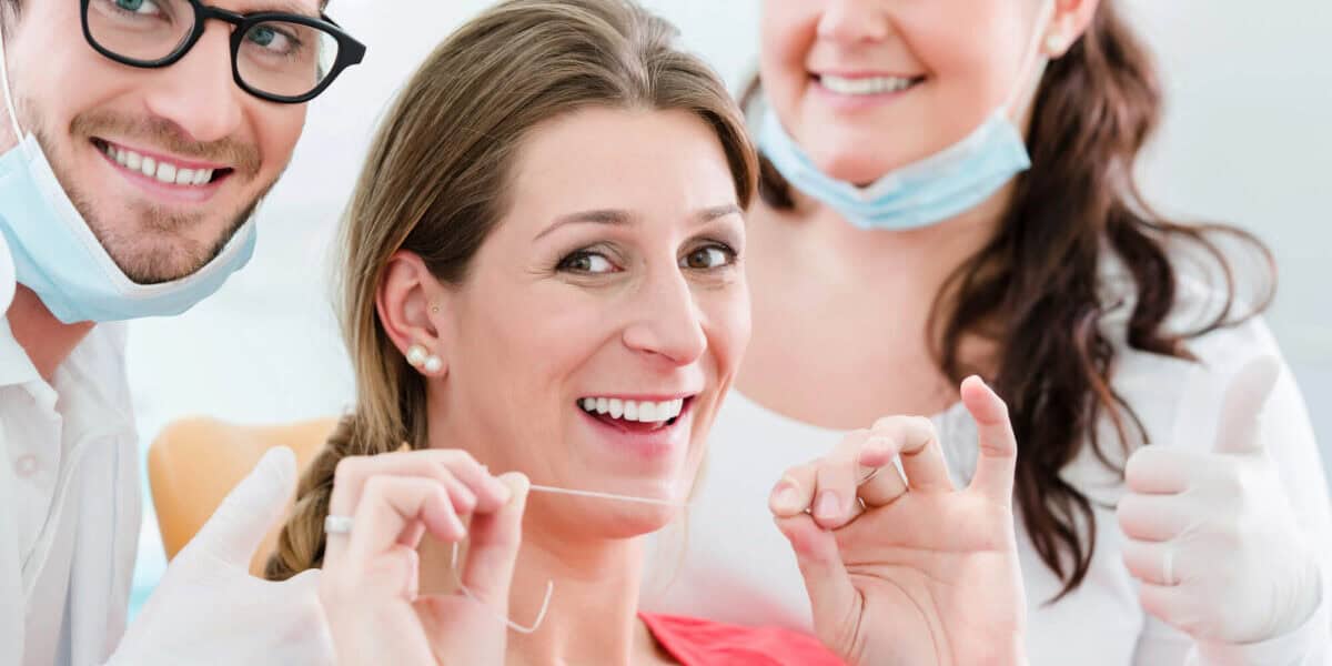patient geting ready to floss after budget-friendly dental cleanings