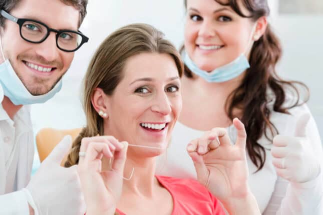 patient geting ready to floss after budget-friendly dental cleanings