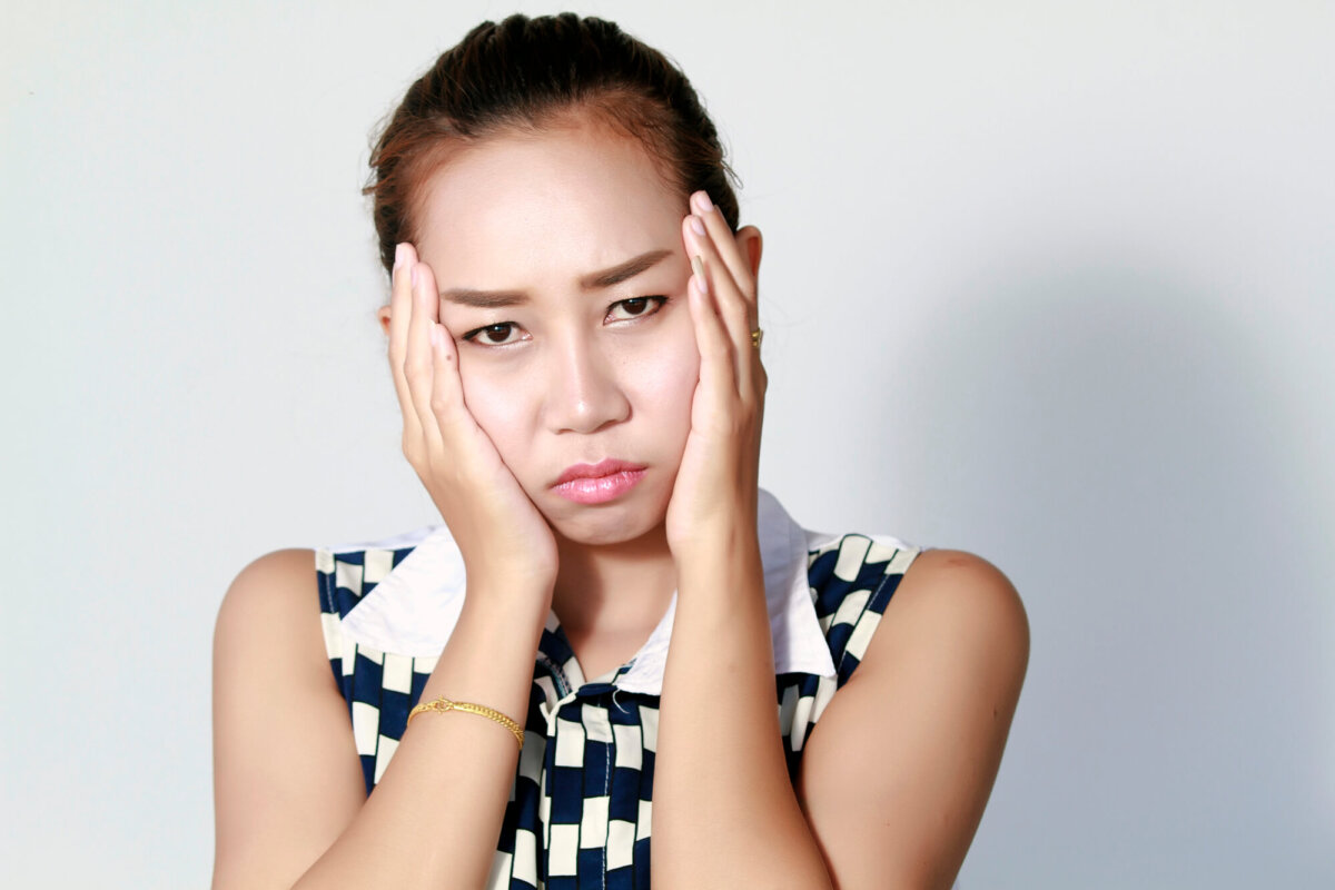 Asian woman in pain and needing Oral Surgery Near Decatur GA